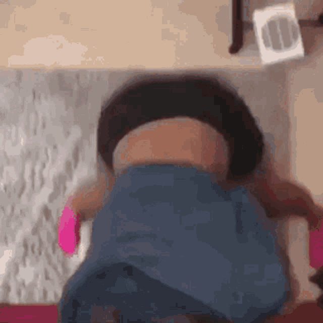a woman is laying on her stomach on the floor while holding a pink toy .