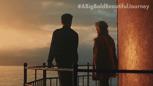 a man and a woman are standing on a balcony overlooking the ocean with the hashtag #abigbold beautiful journey