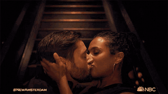 a man and a woman kissing with the nbc logo in the corner