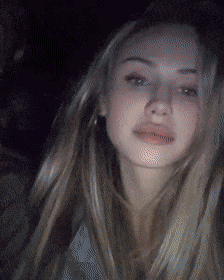 a woman with long blonde hair is looking at the camera