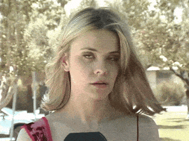 a close up of a woman 's face with a microphone in her hand