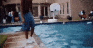 a man is standing on the edge of a swimming pool