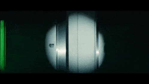 a dark room with a light shining on a door that says ' emergency exit ' on it