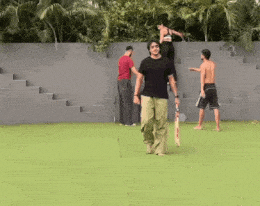a group of people are playing a game of cricket on a green field