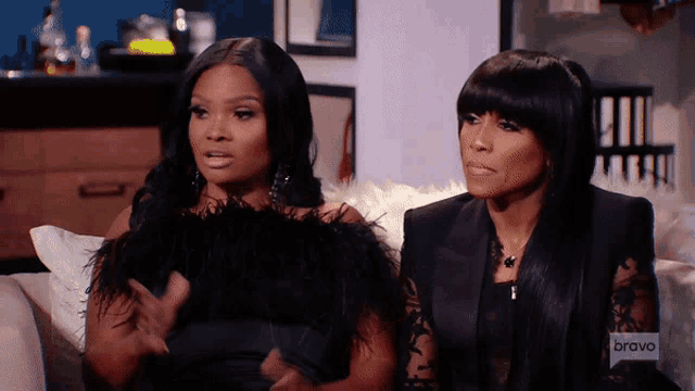 two women are sitting on a couch with bravo written on the bottom of the screen