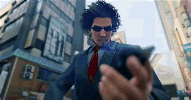 a man in a suit and tie is holding a cell phone in his hand