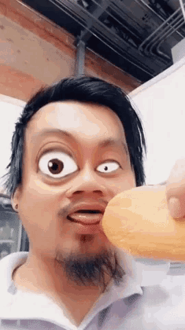 a man with a beard is making a cartoon face while holding a donut