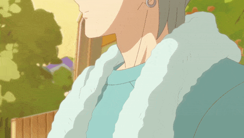 a close up of a person wearing a blue sweater and a white fur collar