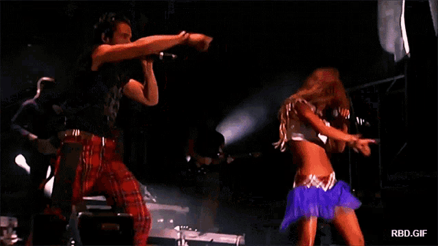 a man and a woman singing on a stage with rbd.gif in the corner