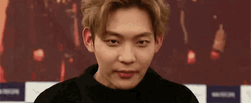 a young man is sticking his tongue out at the camera .
