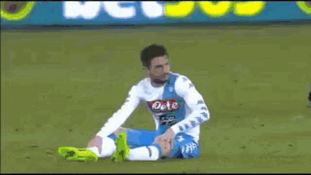 a soccer player is kicking a ball in front of an ad for bet 65
