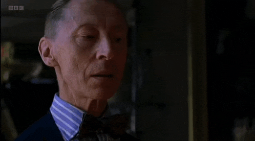 a man in a suit and tie says " deliciously " on the screen