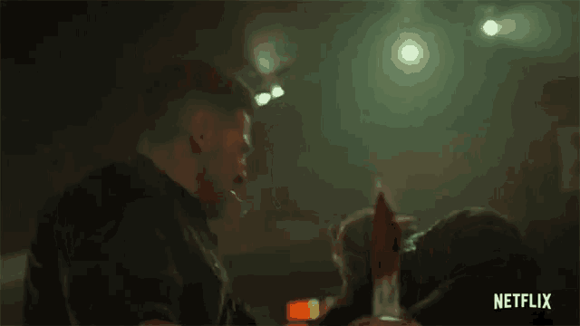 two men are standing next to each other in a dark room with a netflix logo on the bottom
