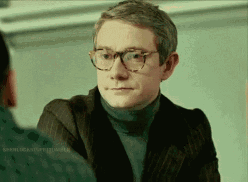 a man wearing glasses and a turtleneck sweater