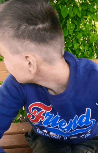 a boy wearing a blue shirt that says friend