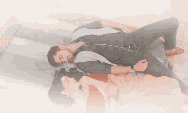 a man and a woman are laying on a bed with the word votr visible