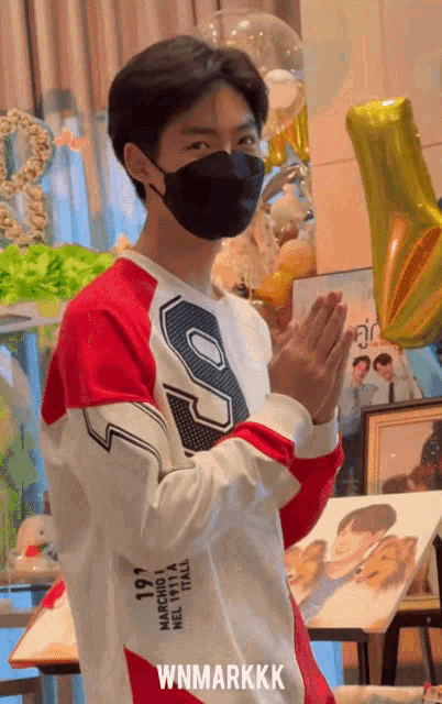 a young man wearing a mask and a shirt that says wnmarkkkk
