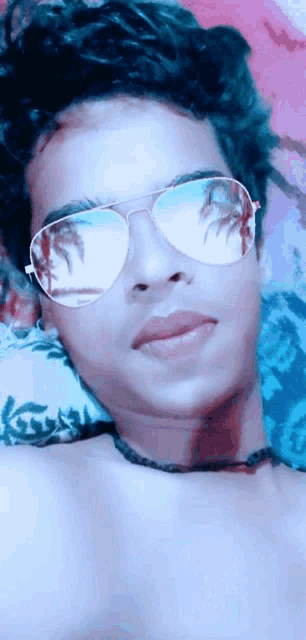 a man wearing sunglasses has a palm tree reflected in his glasses