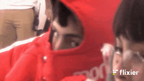 a man wearing a red hoodie with the word flixier on the bottom right