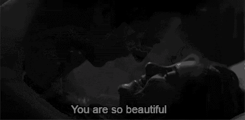 a black and white photo of a woman laying down with the words " you are so beautiful " written above her .