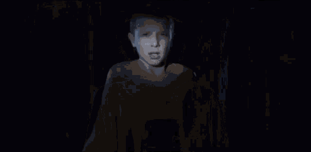 a car is driving down a dark street with its headlights on .