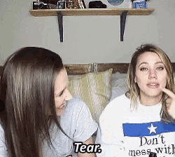 two women are sitting next to each other with one wearing a shirt that says " don t mess with tear "