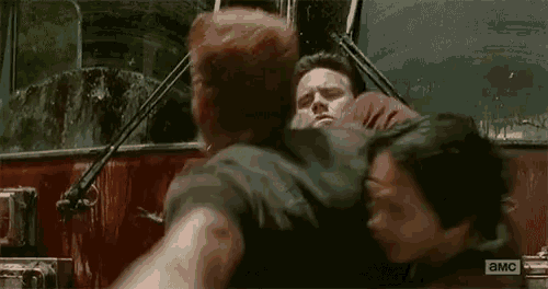 a man and a woman are fighting in a car and the word a.m.c. is on the bottom of the screen .