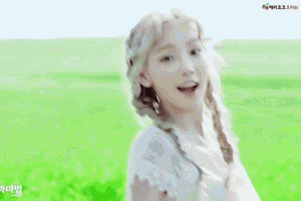 a woman in a white dress is standing in a green field waving her hand .