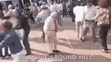a group of elderly people are dancing in a crowd on a sidewalk .