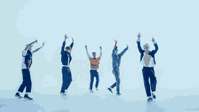 a group of young men are standing in a row and dancing