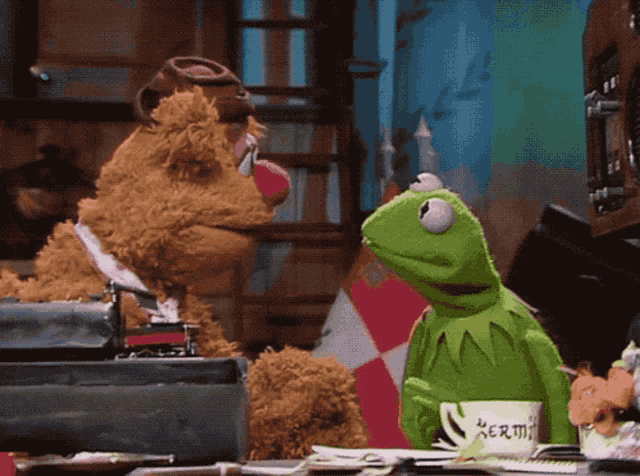 kermit the frog and fozzie bear are sitting at a table with a cup that says kermit on it
