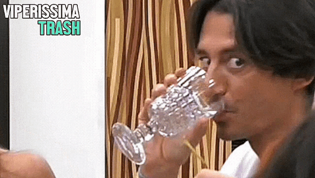a man drinking a glass of water with the words viperissima trash written above him