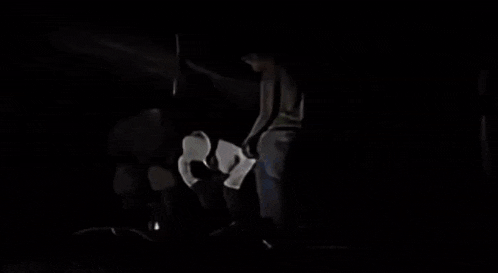 a group of people are sitting under a canopy in the dark