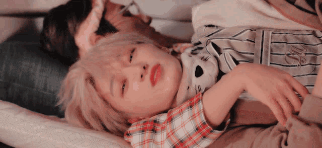 a person laying on a bed with a teddy bear on their chest