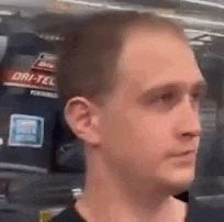 a close up of a man 's face in front of a sign that says dry-tel .