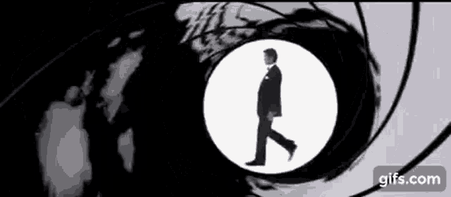 a man in a suit is walking through a circle in front of a camera .