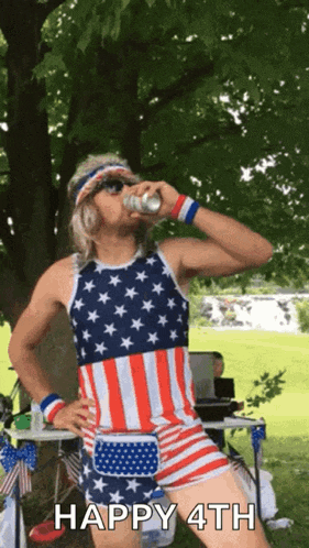a man wearing an american flag outfit is drinking a beer