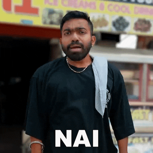 a man with a beard is wearing a black shirt that says nai on it