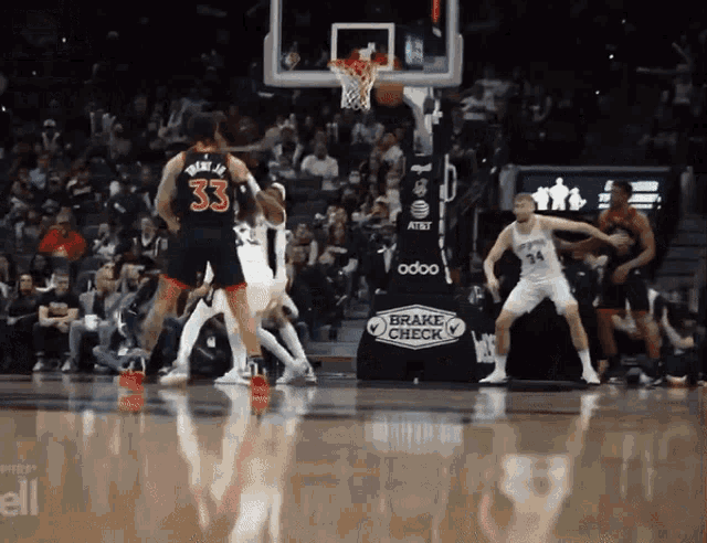 a basketball game is being played in front of a brake check banner