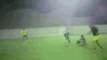 a blurry picture of people playing soccer on a green field