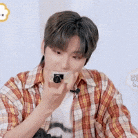 a man in a plaid shirt is taking a picture with his phone .