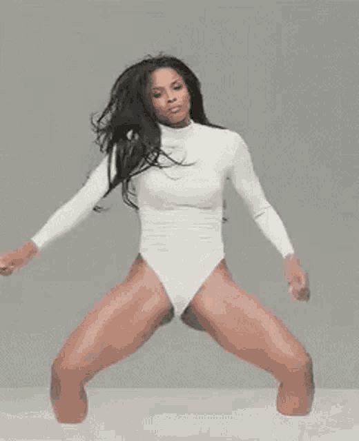 a woman in a white leotard is dancing .