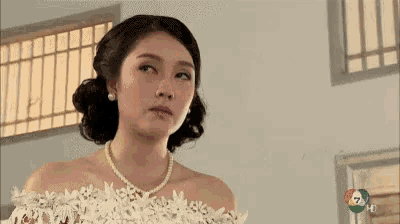 a woman in a white dress and pearls is on a channel 7 hd