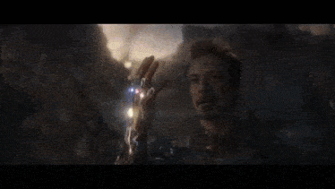 a close up of a man holding a lightning bolt in his hand in a movie scene .