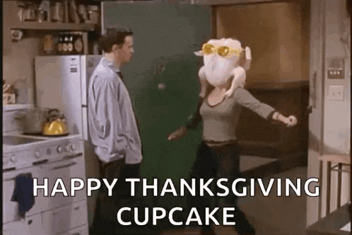 a woman with a turkey head is dancing in a kitchen with a man standing behind her .