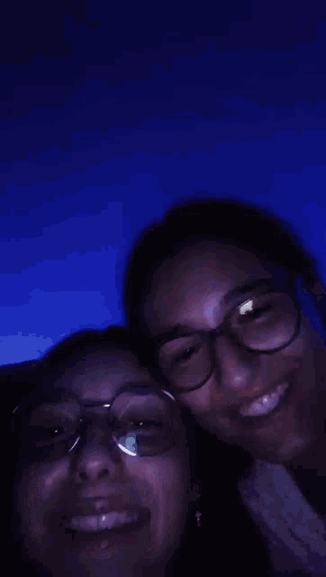 two women wearing glasses are smiling for the camera