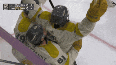 a hockey player with the number 19 on his jersey is hugging another player