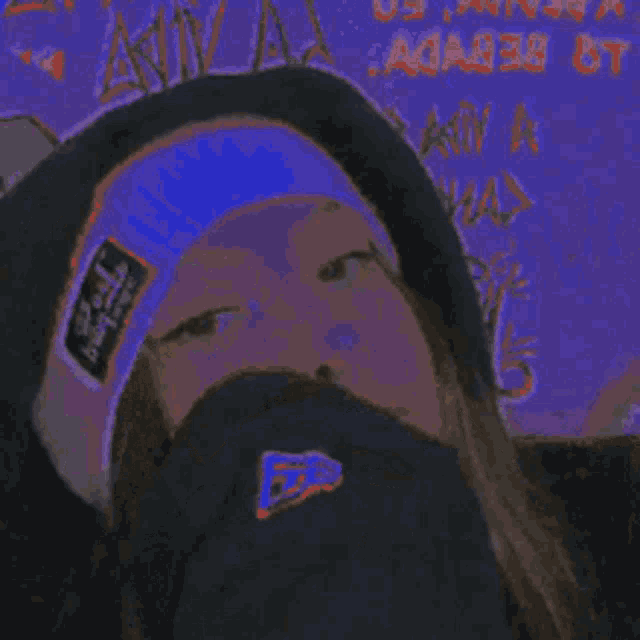 a close up of a woman wearing a purple headband and a black hat .