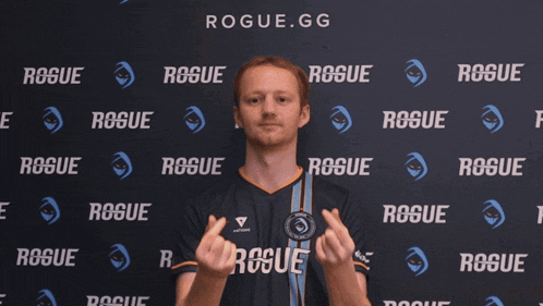 a man in a rogue.gg shirt is making a heart with his hands