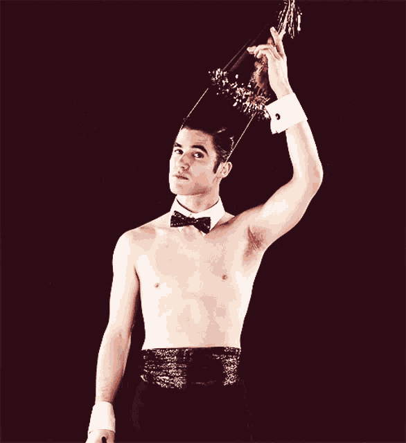 a blurred image of a shirtless man in a tuxedo